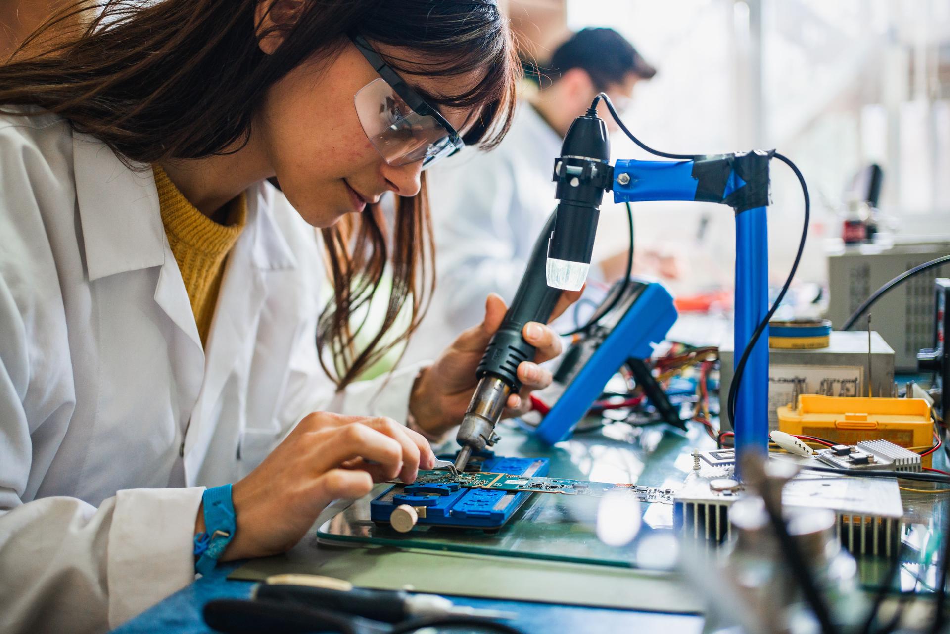 Co-workers working  on a circuit boards in office