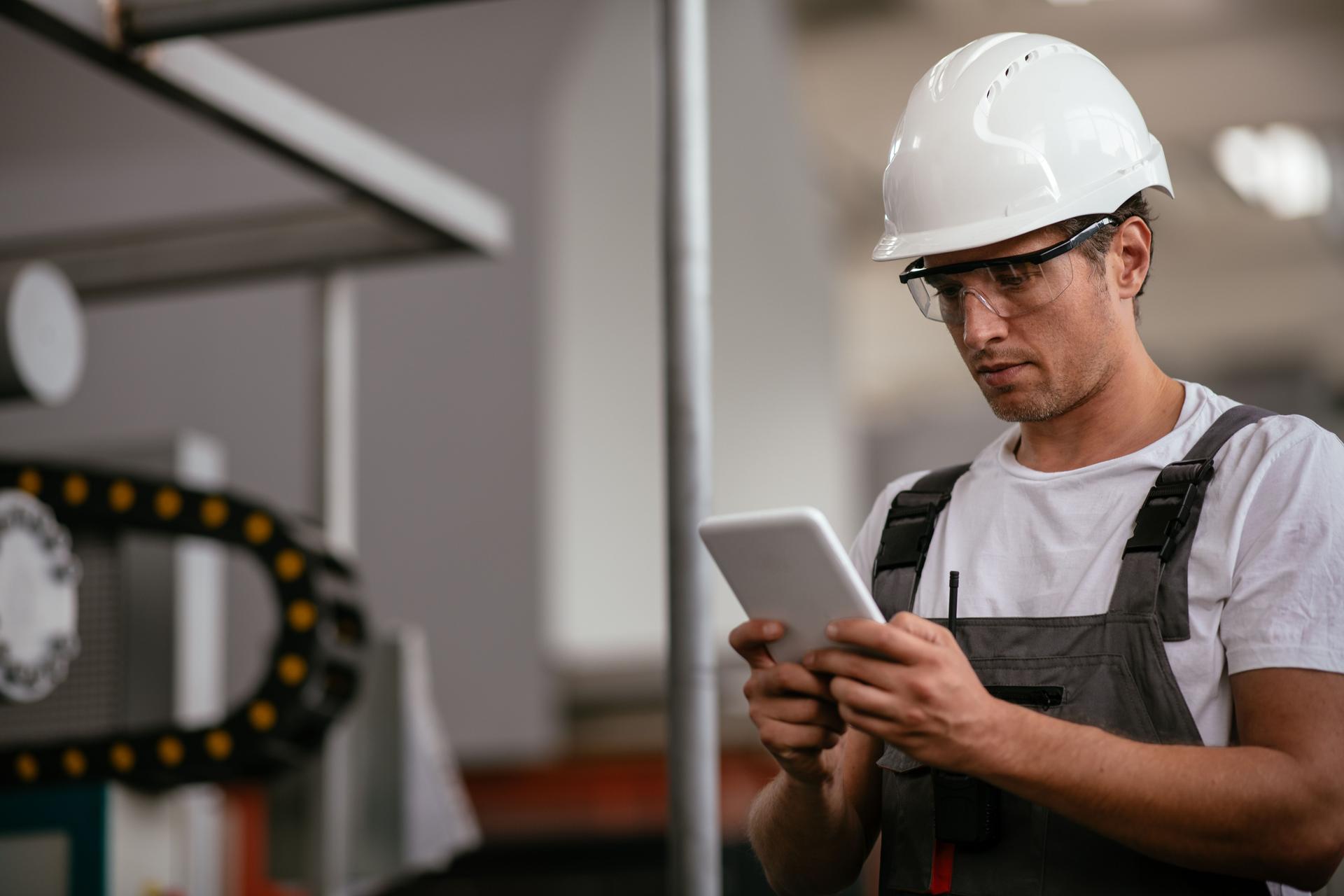 Male engineer in factory using tablet